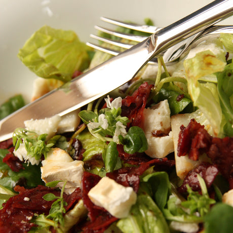 Smoked Spianata salami & goats cheese salad on plate with knife & fork