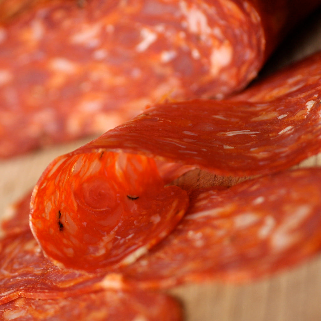 Slices of smoked Spianata Calabra salami on chopping board